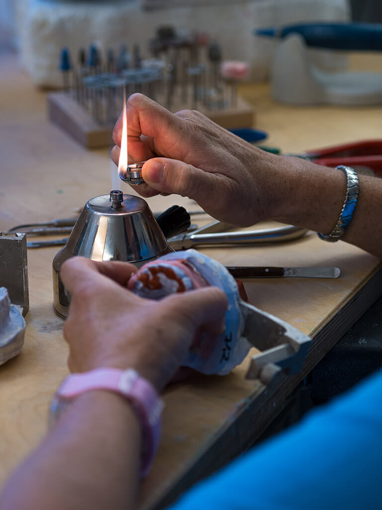 Zahntechniker bei der Bearbeitung einer Zahnspange.